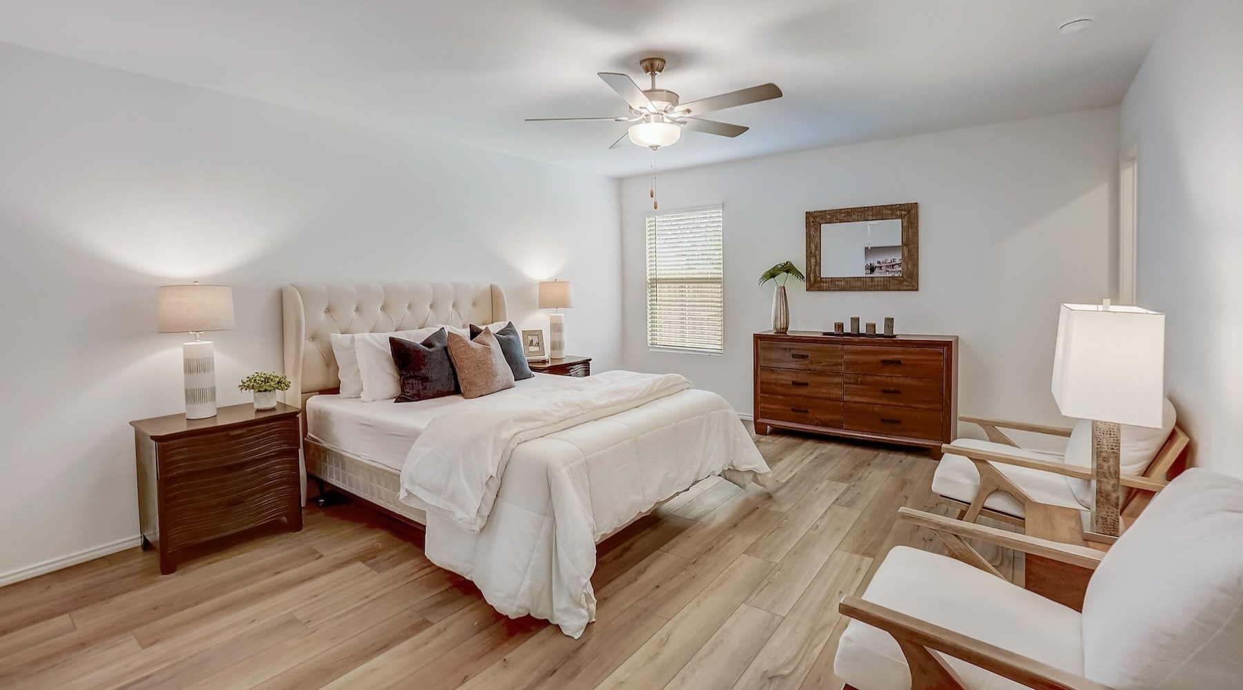 a bedroom with a bed, chairs and tables